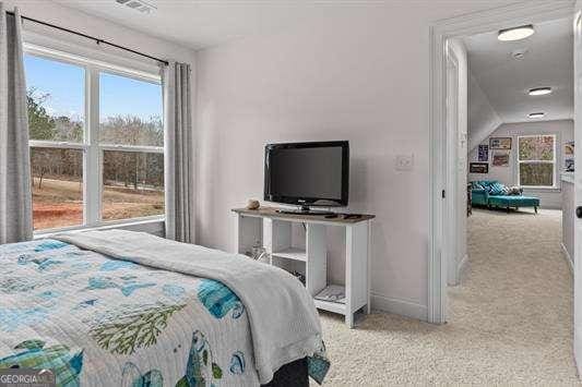 carpeted bedroom featuring multiple windows, visible vents, and baseboards