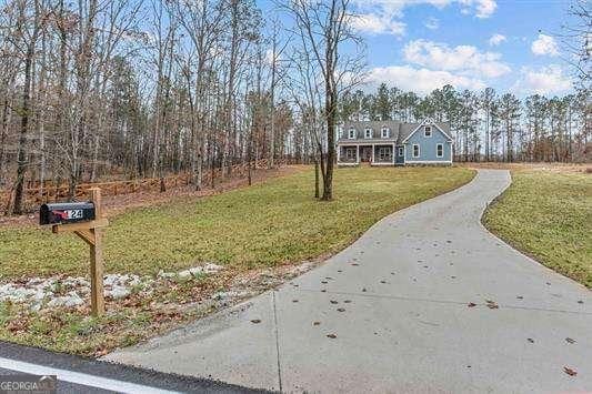 view of front of house with concrete driveway and a front lawn