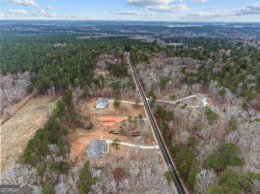 birds eye view of property featuring a forest view