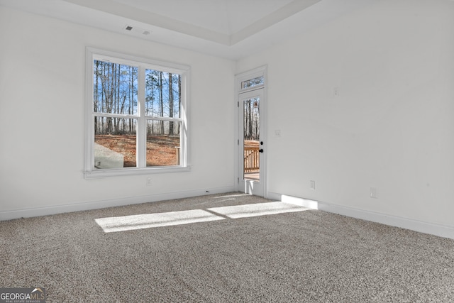 empty room with carpet flooring, visible vents, and baseboards