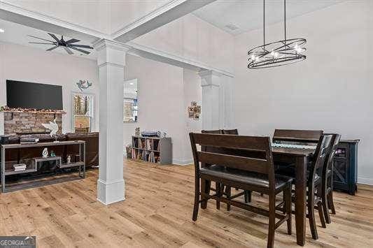 dining area with decorative columns and wood finished floors