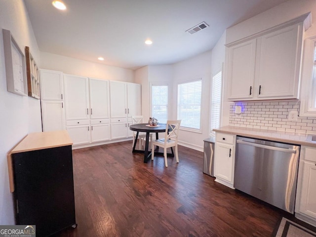 kitchen with backsplash, dark hardwood / wood-style flooring, white cabinets, and stainless steel dishwasher