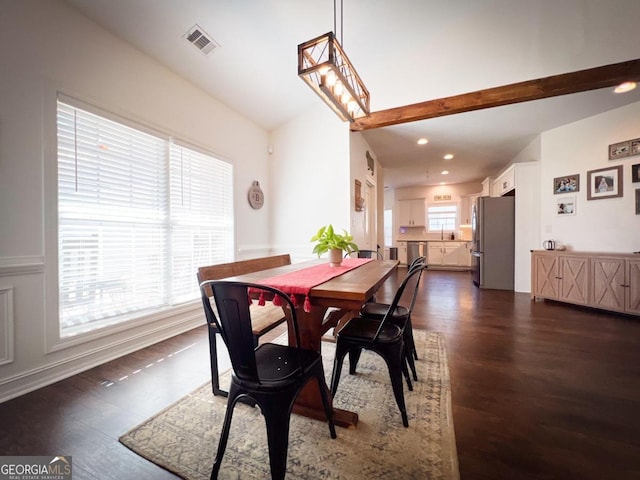 dining room with lofted ceiling, dark wood-type flooring, a healthy amount of sunlight, and sink