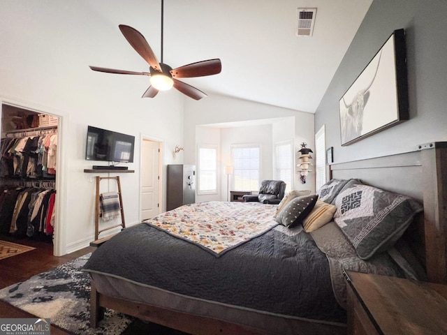 bedroom featuring a spacious closet, ceiling fan, vaulted ceiling, a closet, and hardwood / wood-style flooring