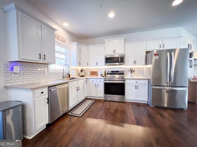 kitchen featuring white cabinetry, sink, stainless steel appliances, tasteful backsplash, and dark hardwood / wood-style flooring