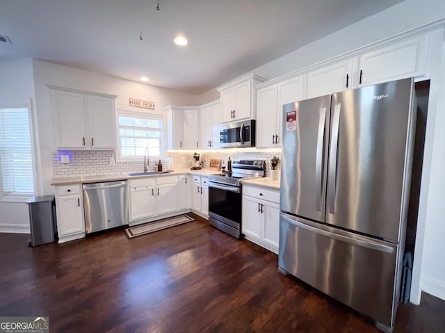 kitchen featuring dark hardwood / wood-style flooring, white cabinetry, sink, and appliances with stainless steel finishes