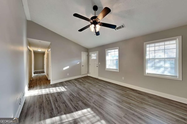 spare room with dark hardwood / wood-style floors, ceiling fan, lofted ceiling, and a textured ceiling