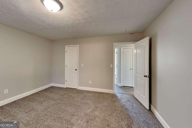 unfurnished bedroom featuring carpet flooring and a textured ceiling