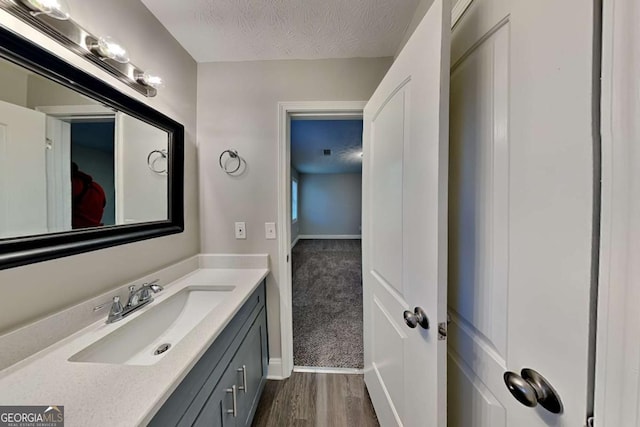 bathroom featuring vanity, a textured ceiling, and hardwood / wood-style flooring