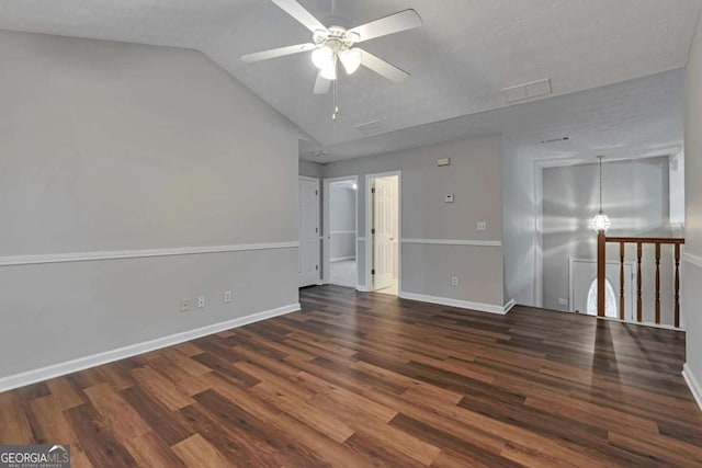 spare room with a textured ceiling, vaulted ceiling, ceiling fan, and dark wood-type flooring