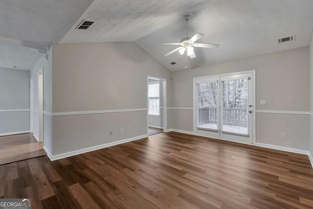 unfurnished room featuring lofted ceiling, ceiling fan, wood-type flooring, and a textured ceiling