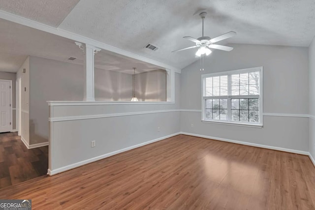 unfurnished room featuring a textured ceiling, ceiling fan, wood-type flooring, and lofted ceiling