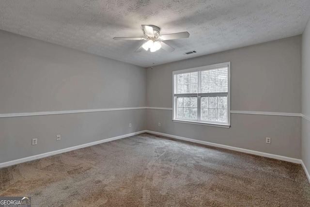 spare room featuring carpet, ceiling fan, and a textured ceiling