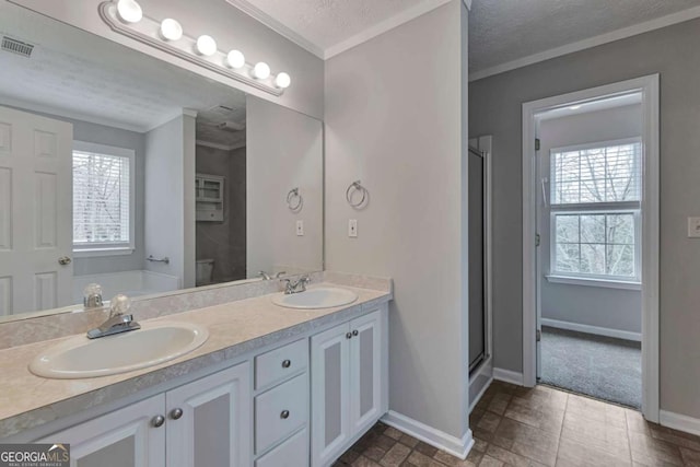 bathroom with vanity, a textured ceiling, a shower with shower door, and ornamental molding