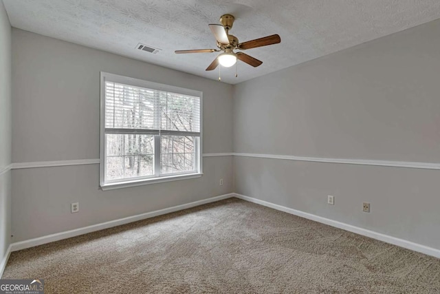 carpeted empty room featuring ceiling fan and a textured ceiling