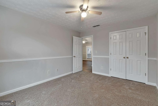 unfurnished bedroom with carpet flooring, ceiling fan, and a textured ceiling