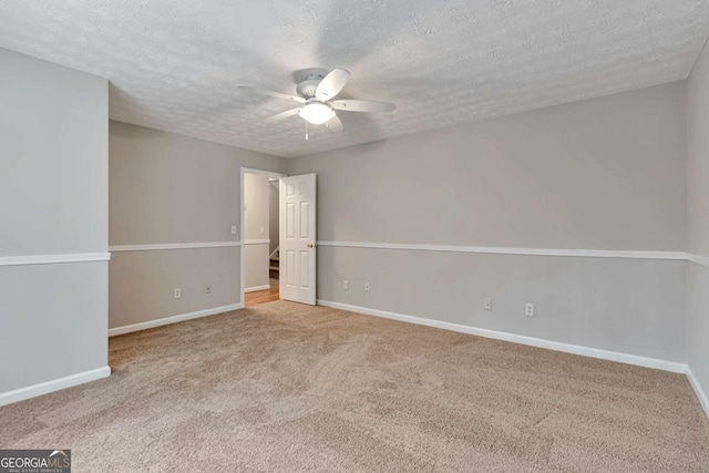 carpeted spare room with ceiling fan and a textured ceiling