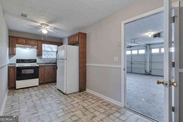 kitchen with a textured ceiling and white appliances