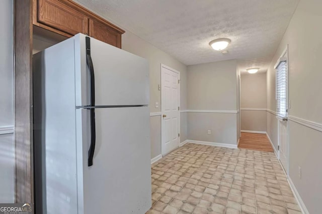 kitchen featuring white fridge and a textured ceiling