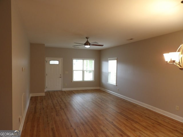 foyer entrance with ceiling fan with notable chandelier and hardwood / wood-style flooring