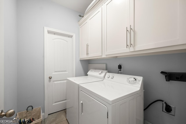 laundry room featuring washer and dryer, cabinets, and light tile patterned floors