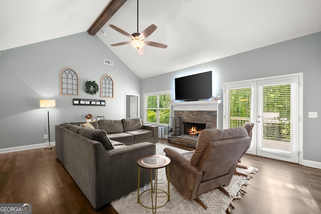 living room with ceiling fan, a fireplace, beamed ceiling, and a healthy amount of sunlight