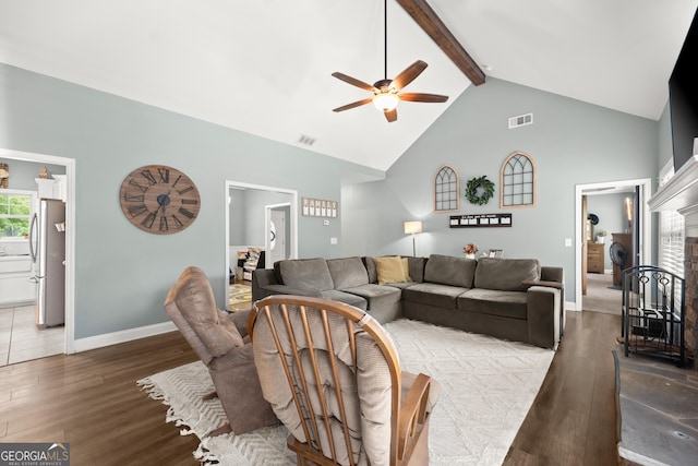 living room with vaulted ceiling with beams, ceiling fan, a fireplace, and dark hardwood / wood-style floors