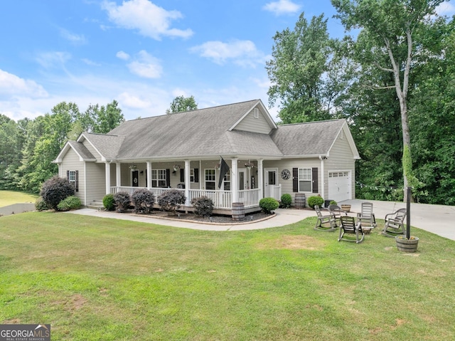 view of front of house featuring covered porch, a garage, and a front lawn