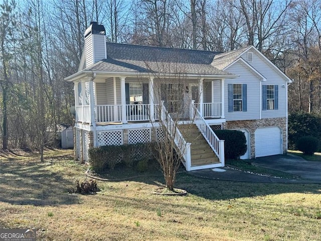 view of front facade with covered porch, a garage, and a front yard