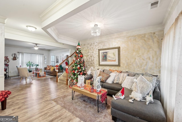 living room featuring crown molding, ceiling fan with notable chandelier, and hardwood / wood-style flooring