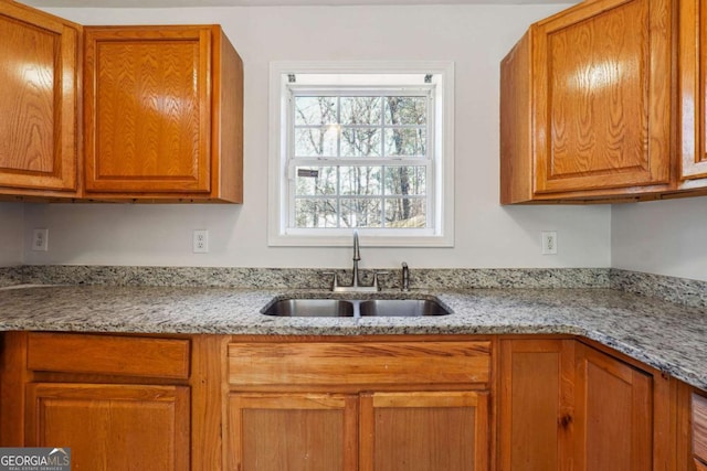 kitchen with light stone countertops and sink