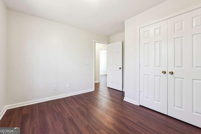 unfurnished bedroom featuring dark hardwood / wood-style floors and a closet