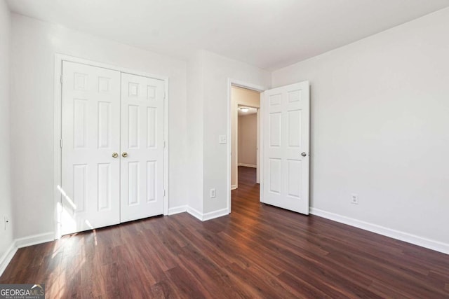 unfurnished bedroom featuring a closet and dark hardwood / wood-style floors