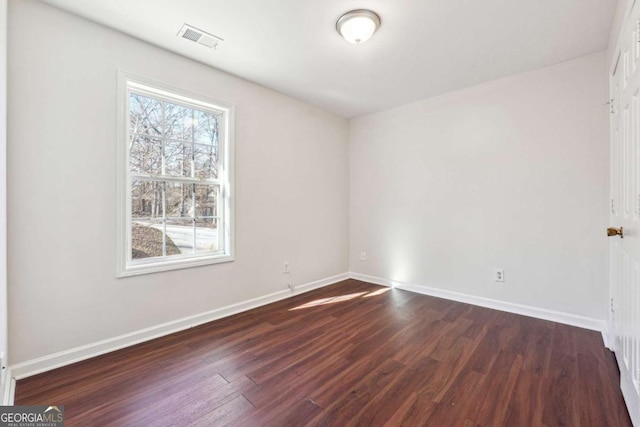 unfurnished room with dark wood-type flooring