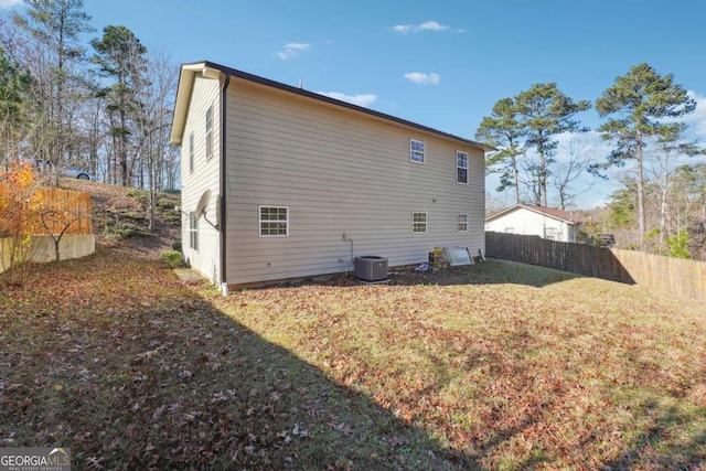 rear view of property featuring a yard and central AC