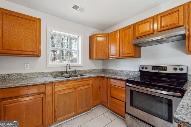 kitchen with stainless steel range with electric stovetop, exhaust hood, sink, light tile patterned floors, and light stone countertops