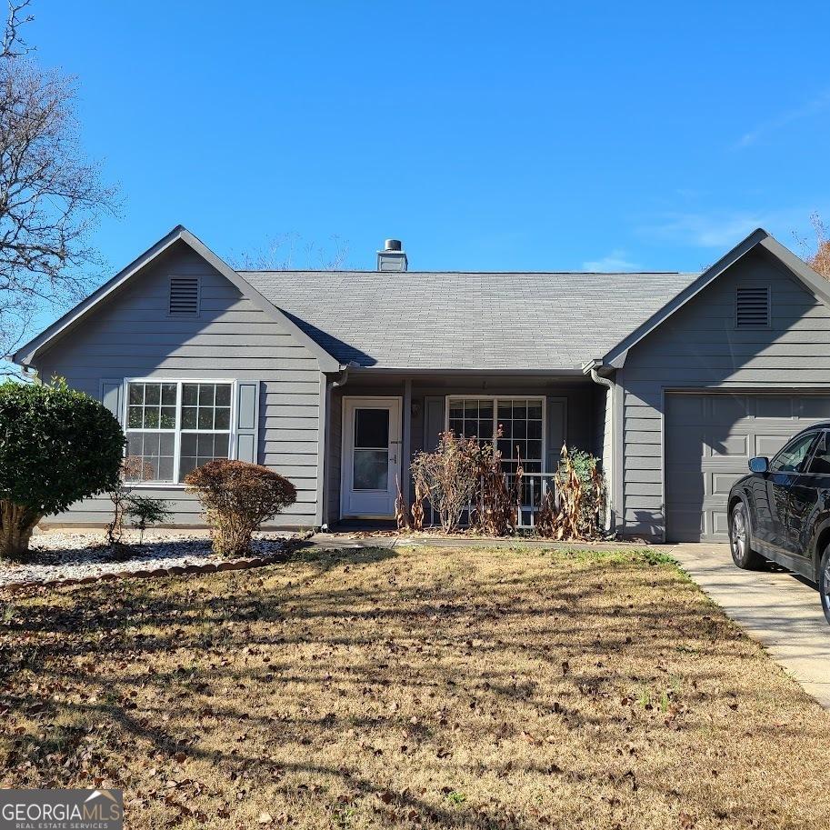 ranch-style home featuring a front yard and a garage