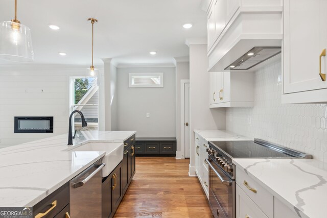 kitchen featuring ceiling fan, decorative light fixtures, light wood-type flooring, white cabinetry, and ornamental molding