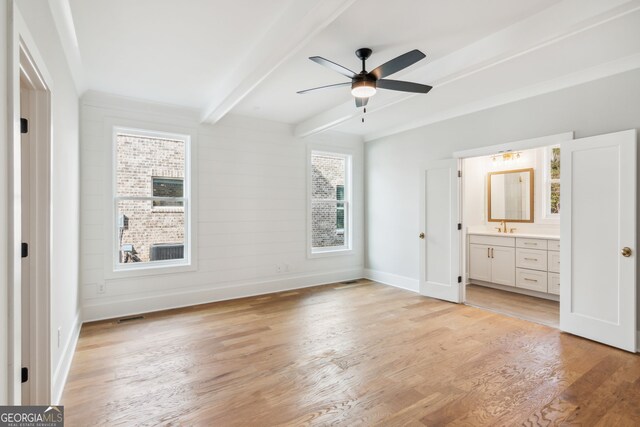 unfurnished living room featuring ceiling fan, a large fireplace, light hardwood / wood-style flooring, and crown molding