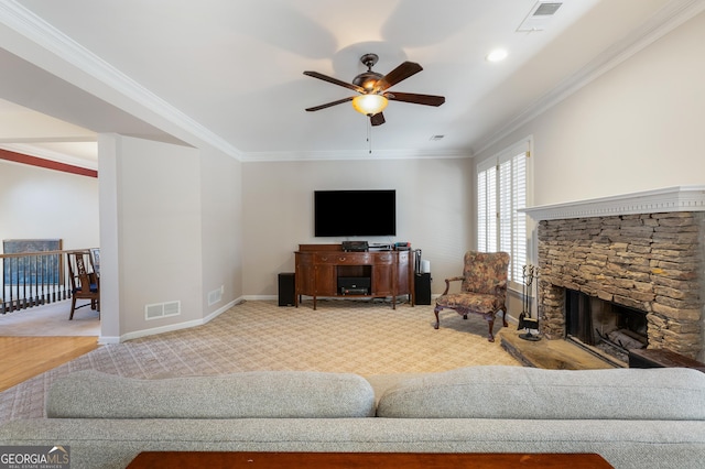 living room featuring crown molding, carpet flooring, ceiling fan, and a fireplace