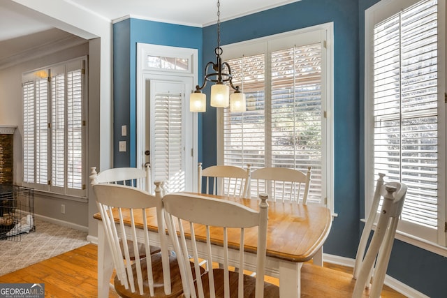 dining area featuring ornamental molding, an inviting chandelier, and light hardwood / wood-style floors