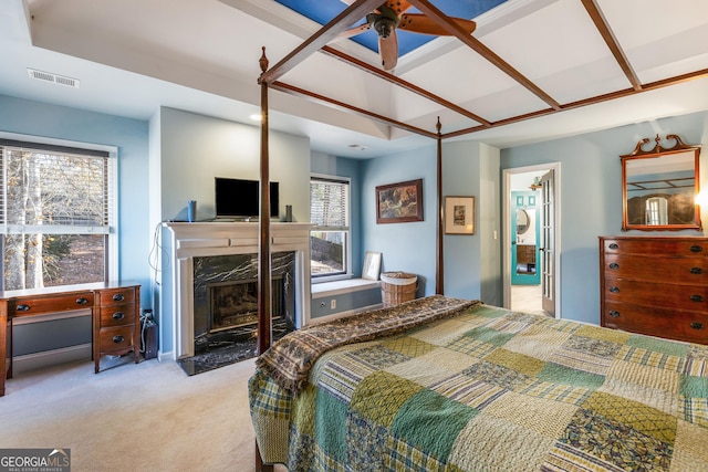 carpeted bedroom featuring a premium fireplace and multiple windows