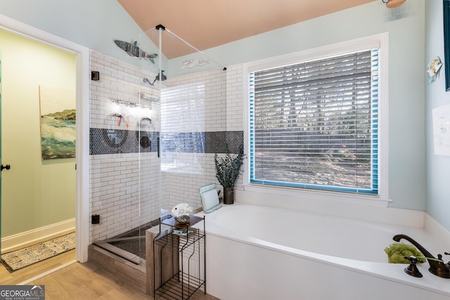 bathroom with hardwood / wood-style flooring, shower with separate bathtub, and lofted ceiling