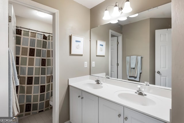 bathroom with an inviting chandelier, tile patterned floors, vanity, and toilet