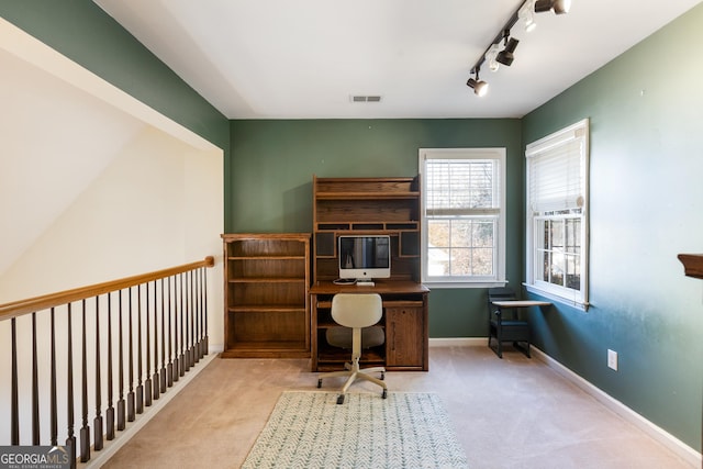 carpeted office featuring track lighting