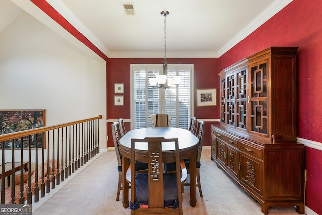 carpeted dining room featuring crown molding and a chandelier