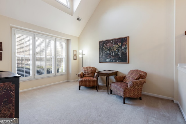 living area with high vaulted ceiling and light colored carpet