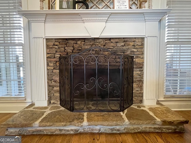 details featuring a stone fireplace and hardwood / wood-style floors