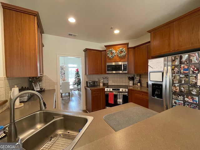 kitchen with stainless steel appliances, sink, and backsplash