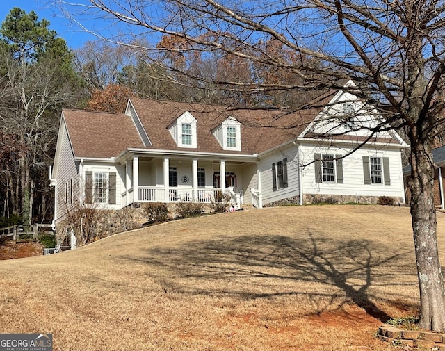 cape cod house featuring a front yard and covered porch